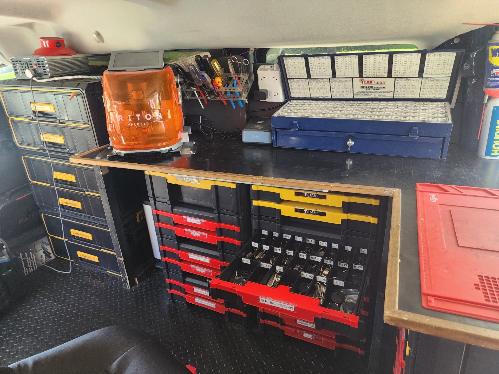 Inside the Overland Park Locksmith mobile service van showing organized key blanks, Triton cutting machine, and locksmith tools