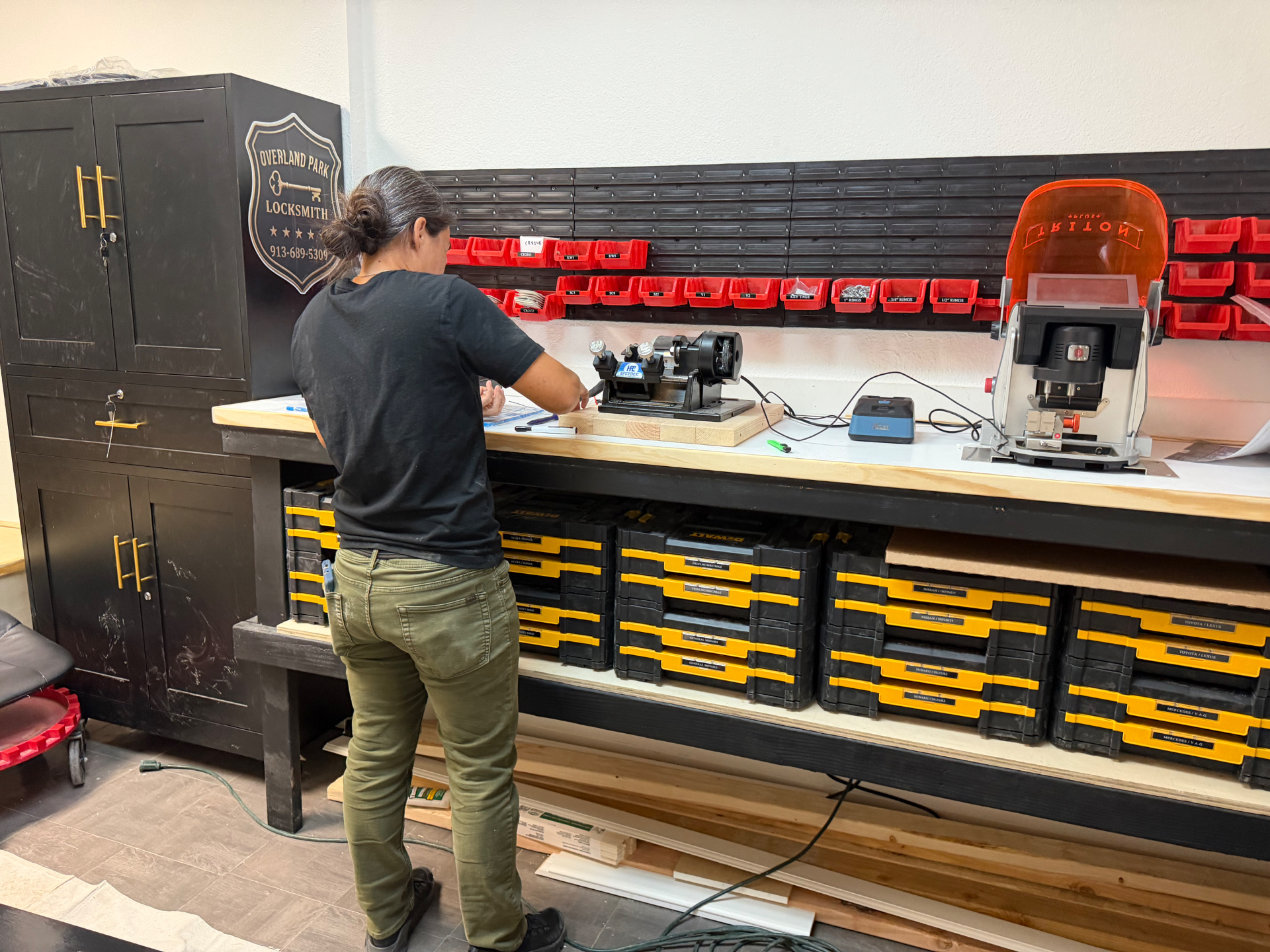 Locksmith technician cutting keys at the Overland Park Locksmith shop workbench